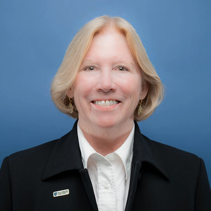 Renee Citera smiles into the camera against a blue background.