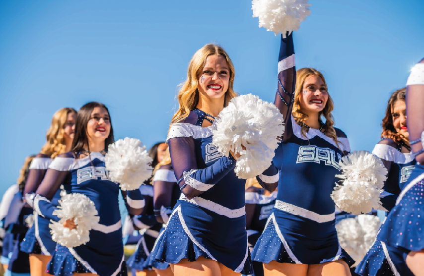3 Cheerleaders walking onto the football field