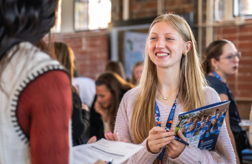 A student smiling at another student while talking