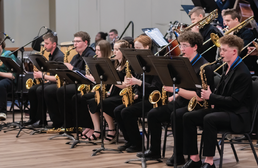 A group a saxophones playing at a band concert
