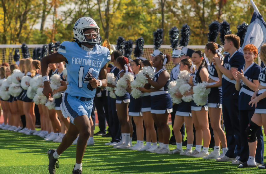 football player running by cheerleaders