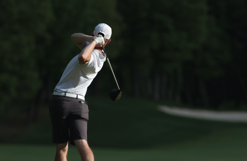 View of person swinging golf club.