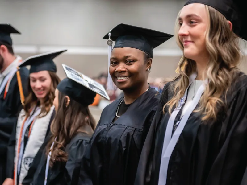 Student smiling in cap and gown.