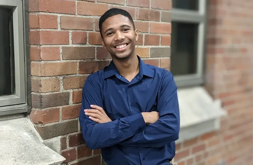 A young man leaning against a wall.