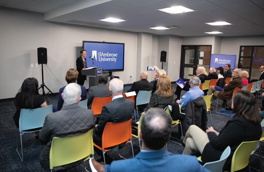 Amy Novak presenting to a room full of peopl.