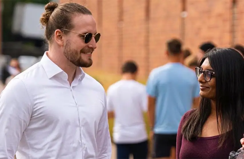 A young man standing with a young woman.
