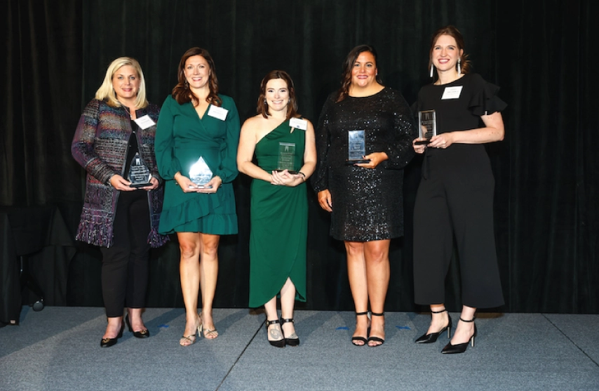 A group of alumni holding awards.