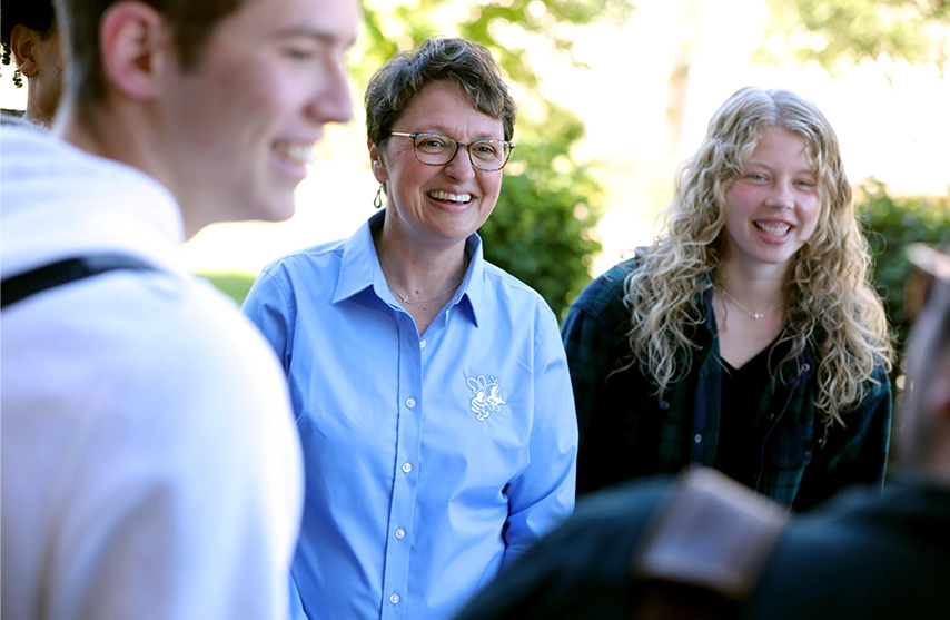 St. Ambrose University President Amy C. Novak, EdD smiles in a group outdoors.