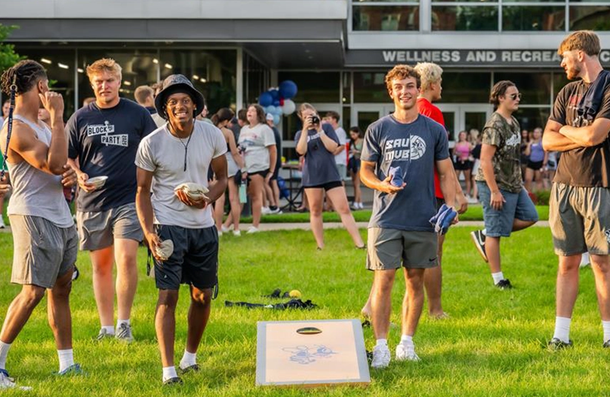Students at St. Ambrose University play cornhole together during the annual block party.