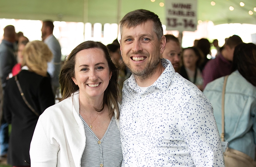 Danielle (Fennelly) ’06 and Kaylon Spengler ‘06 smile into the camera during St. Ambrose University's 2024 Wine Fest.