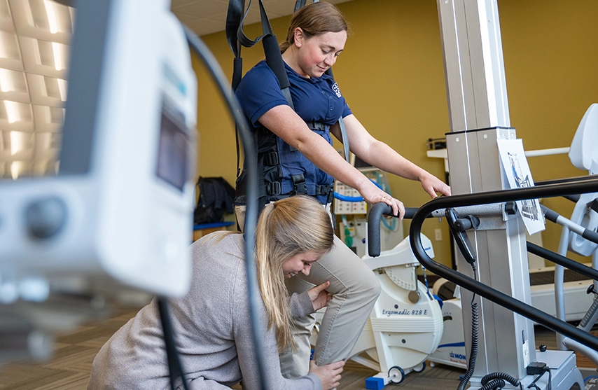Two students practice phyiscal therapy techniques.