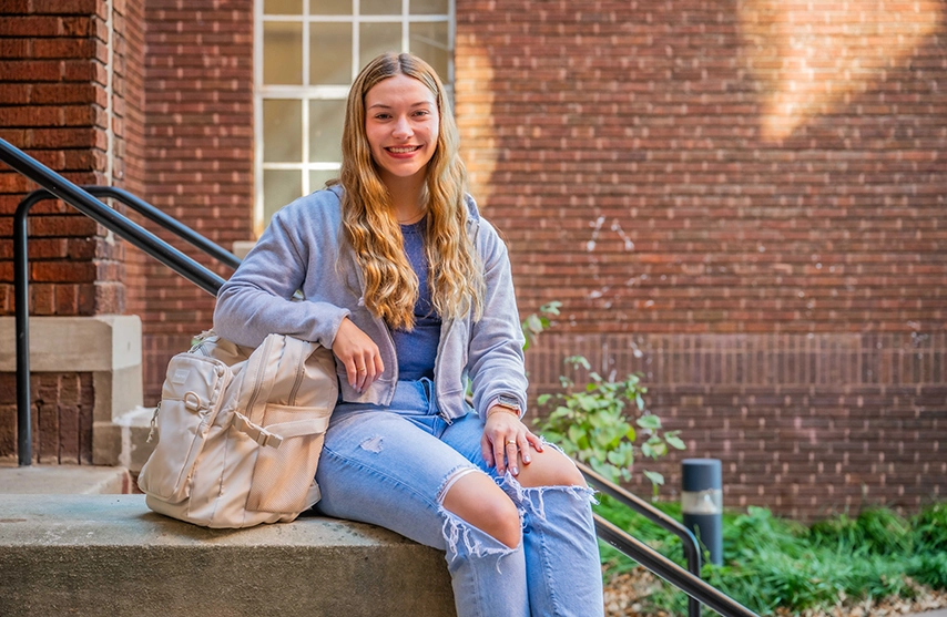 Evelyn Waters smiles at the camera while sitting outside.