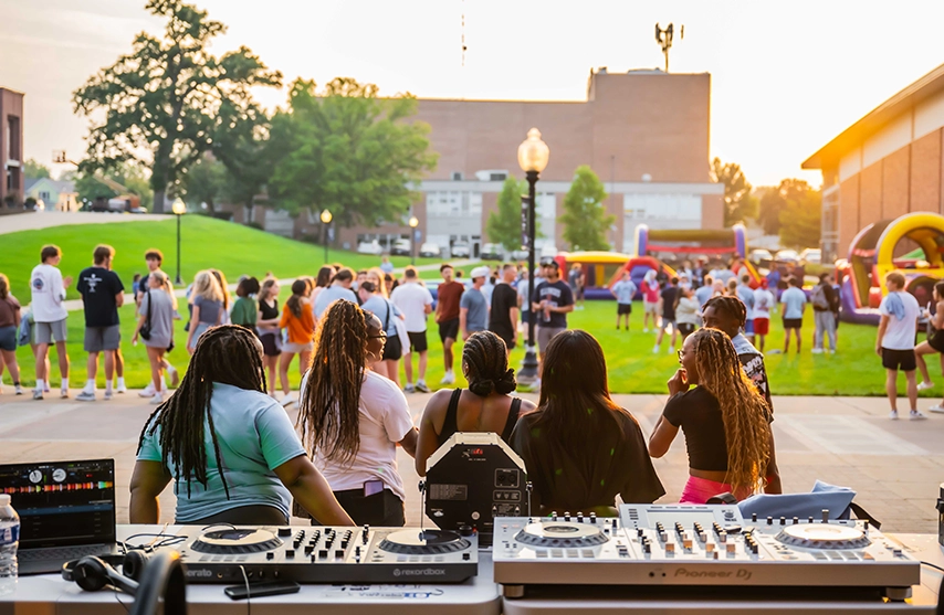 In the fading sun, students listen to live music, play on bounce houses, and enjoy each other's company.