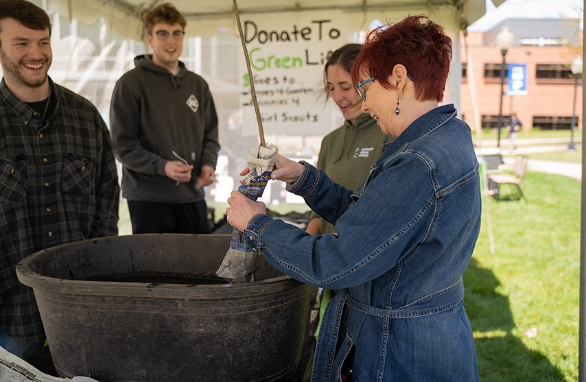 A group of students gather around a tub of water at a Green Life event.