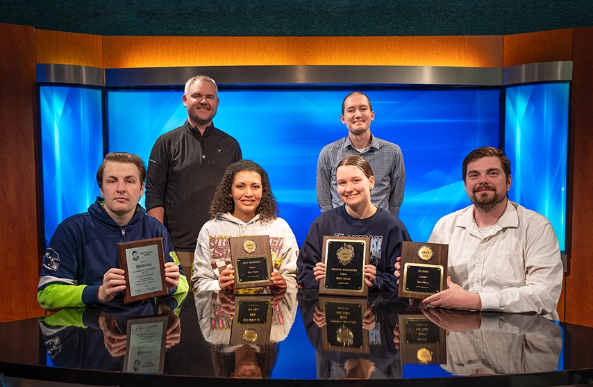 Students and faculty from SAU's multimedia communications program smile as they hold their awards for the 2026 season.