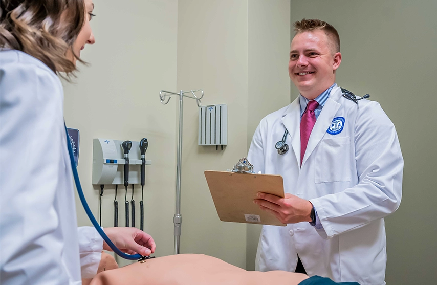 Two students practice medical care in the Master of Physician Assistant Studies program at St. Ambrose University.