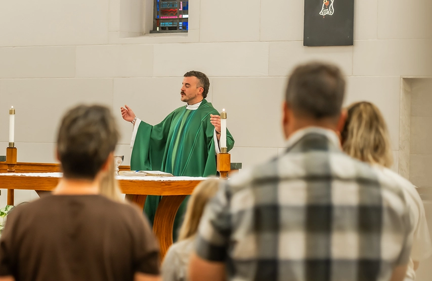 An audience watches a religious official dressed in green.