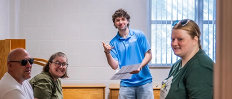 A new student and his family stand in his new dorm room at St. Ambrose University.