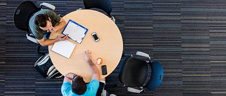 Two students at St. Ambrose University sit around a table and study.