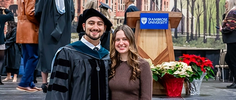 Vince Thomas ’23, DPT ’25 and Abby (Cowan) ’23 stand together at the St. Ambrose University Commencement ceremony.