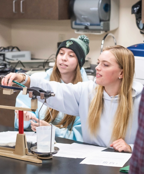 Two engineering students collaborating on a project in a lab.
