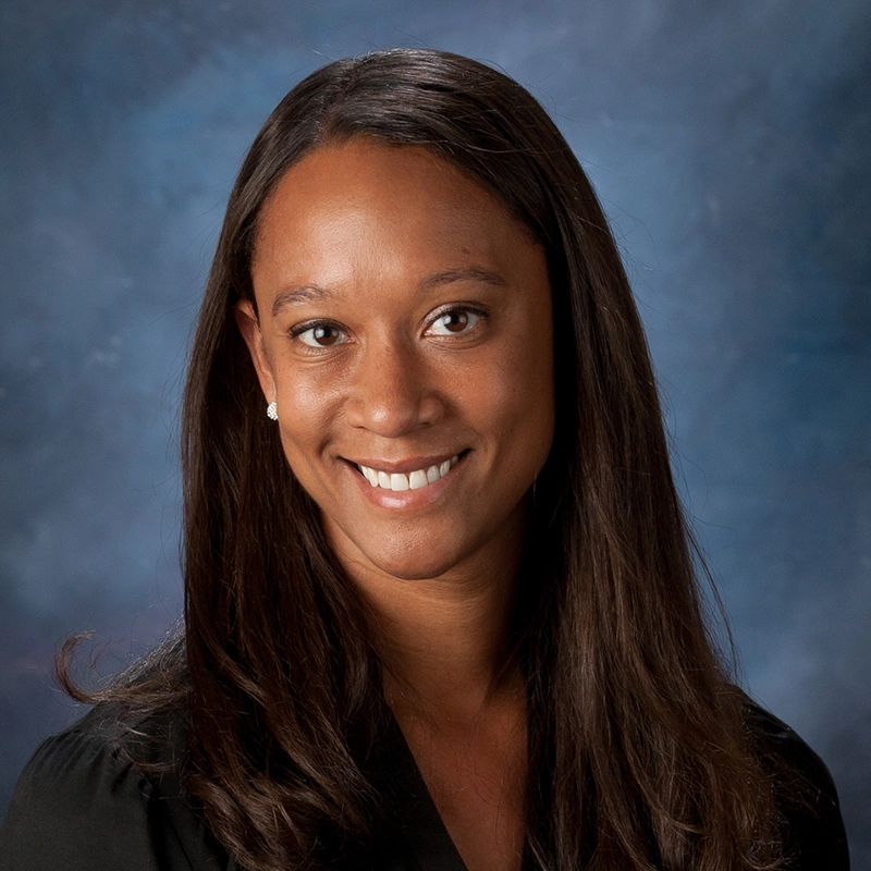 Sara Pearson smiles at the camera against a blue background.